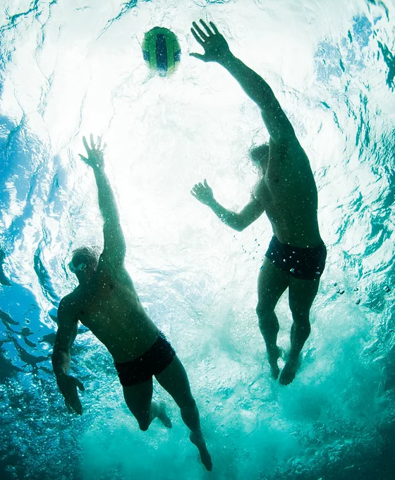 Water polo players chasing ball